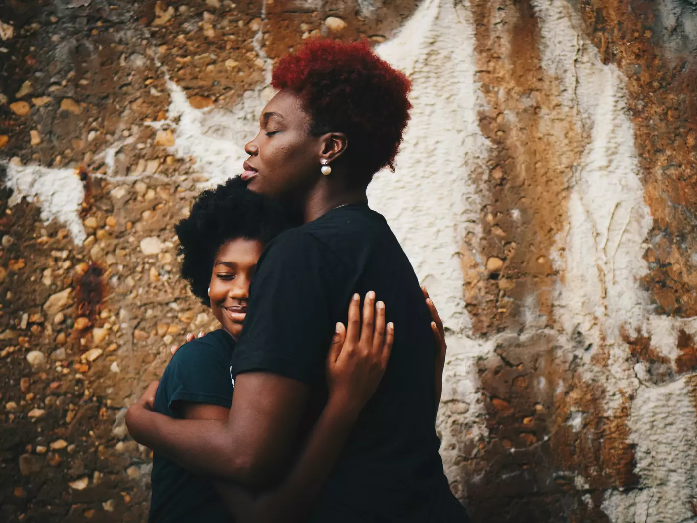 A mother holding her teenage son close, his face lit with a smile